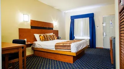 Cama o camas de una habitación en American Inn Hotel & Suites Delicias