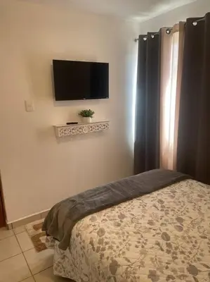 Una televisión o centro de entretenimiento en Departamento cómodo e impecable