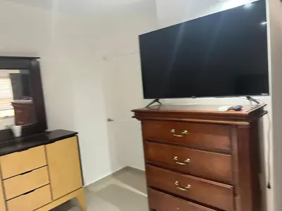Una televisión o centro de entretenimiento en Casa 2 habitaciones más sofá