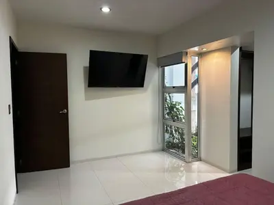 Una televisión o centro de entretenimiento en Depa Frente al Parque Central, Excelente Ubicacion