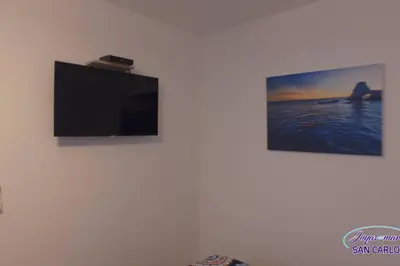 Una televisión o centro de entretenimiento en Departamento Topacio 3 Joyas del Mar San Carlos